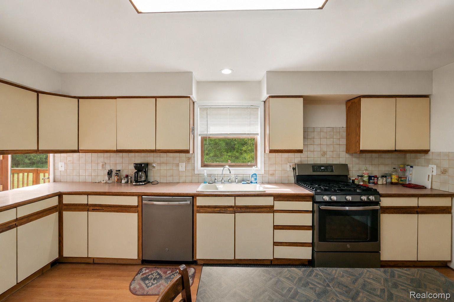 76565 McFadden Road Armada, MI 48005 - Photo 19 of 95 Efficient kitchen layout featuring abundant cabinetry, a gas range, stainless steel dishwasher, and a skylight