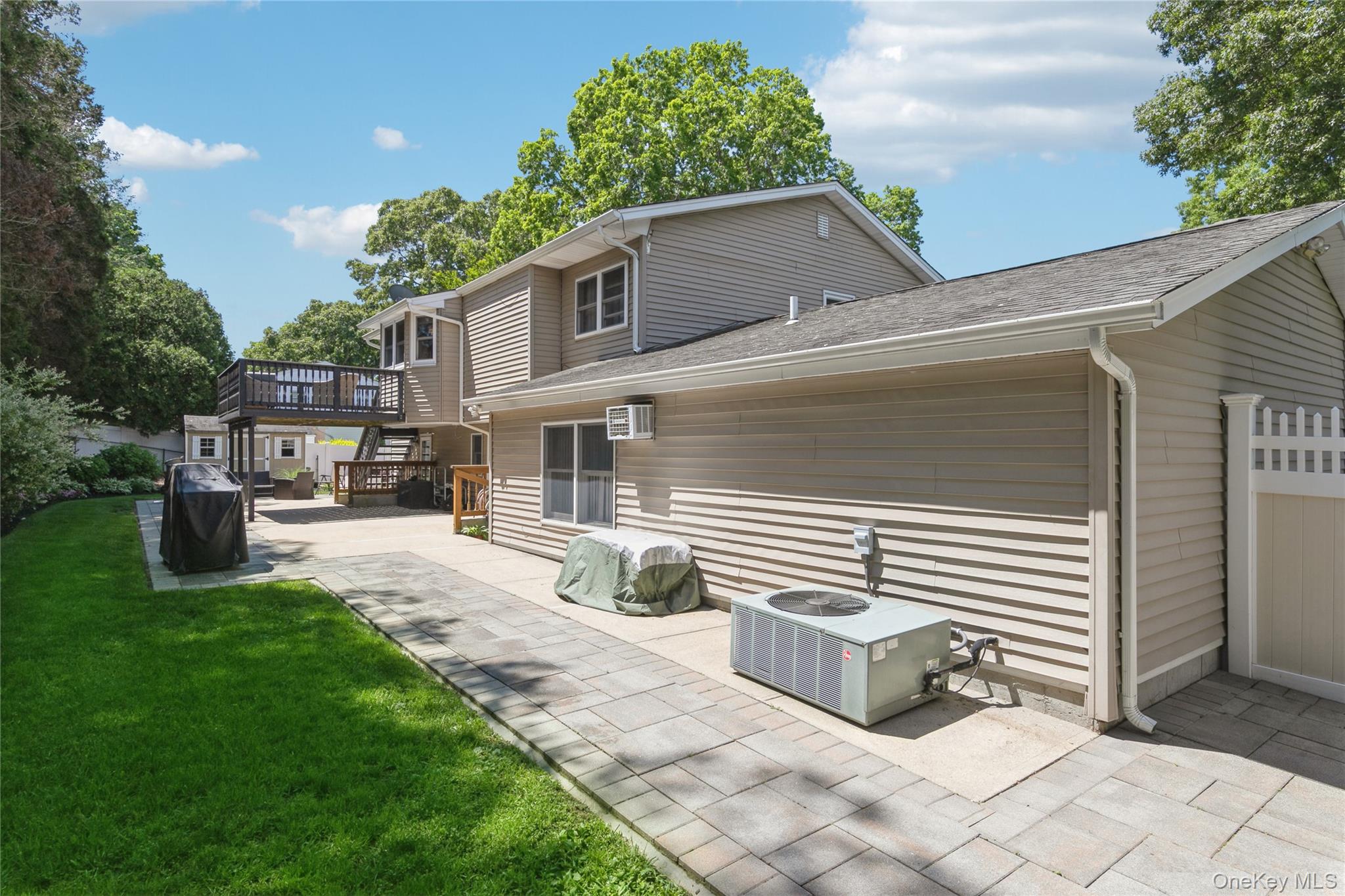 115 Clarendon Road Ronkonkoma, NY 11779 - Photo 37 of 45 Expansive paver patio with a manicured lawn border