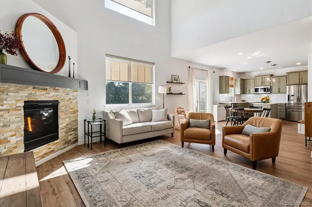a living room with furniture a fireplace a rug and a window