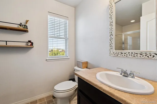 a bathroom with a granite countertop sink toilet and a mirror