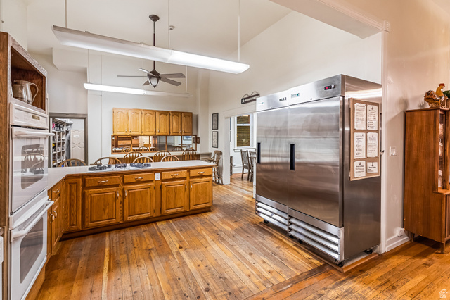 21 North Main Street Kingston, UT 84743 - Photo 67 of 107 Kitchen featuring stainless steel refrigerator, dark wood-style flooring, double oven, wood finish cabinetry, and lofted ceiling