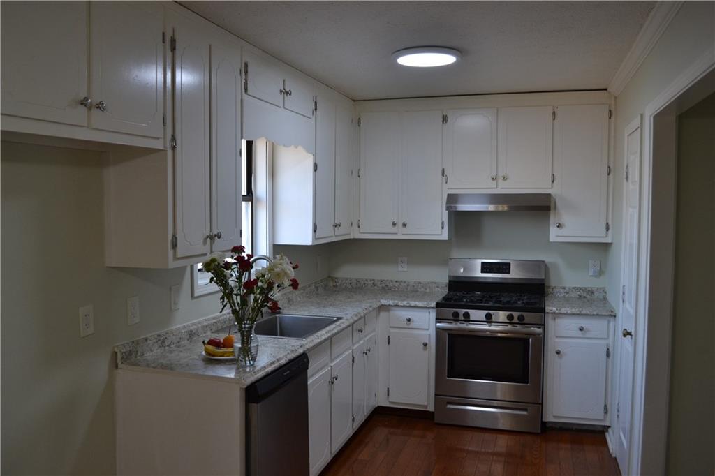 555 Lee Byrd Road Loganville, GA 30052 - Photo 11 of 23 a kitchen with stainless steel appliances a sink stove and cabinets