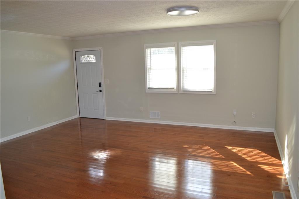 555 Lee Byrd Road Loganville, GA 30052 - Photo 15 of 23 a view of an empty room with wooden floor and a window