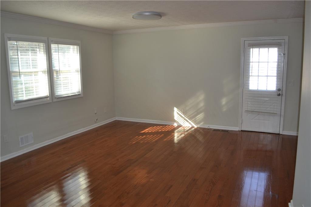 555 Lee Byrd Road Loganville, GA 30052 - Photo 16 of 23 an empty room with wooden floor and windows