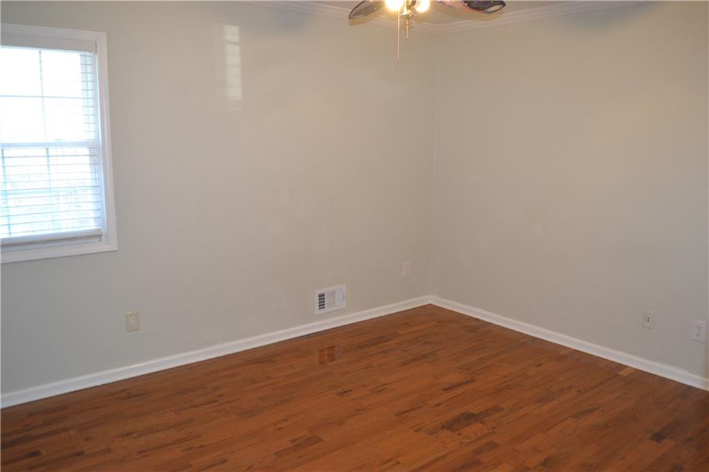 555 Lee Byrd Road Loganville, GA 30052 - Photo 20 of 23 an empty room with wooden floor and windows