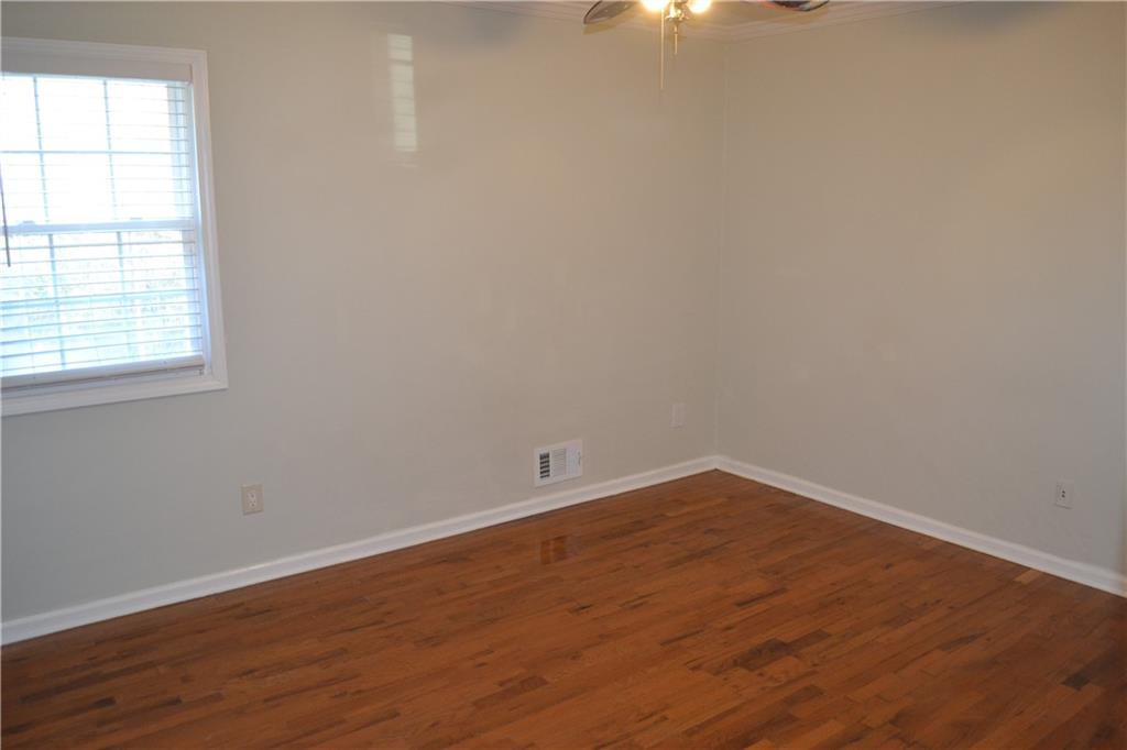 555 Lee Byrd Road Loganville, GA 30052 - Photo 21 of 23 an empty room with wooden floor and windows