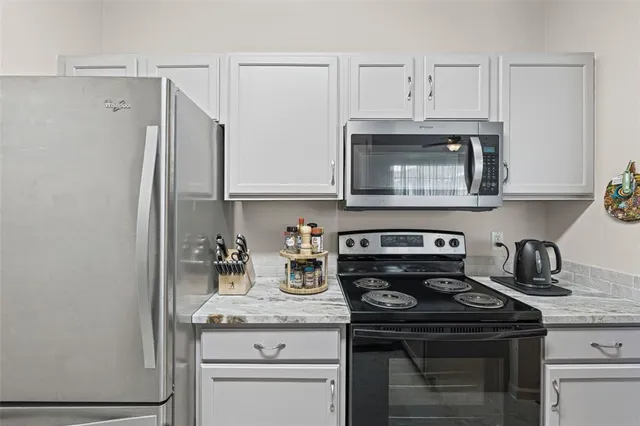 a kitchen with stainless steel appliances granite countertop a sink a stove and cabinets