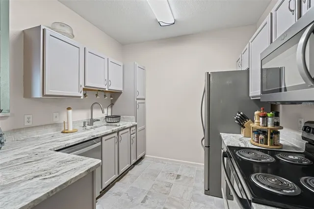 a kitchen with stainless steel appliances granite countertop a stove and a refrigerator with cabinets