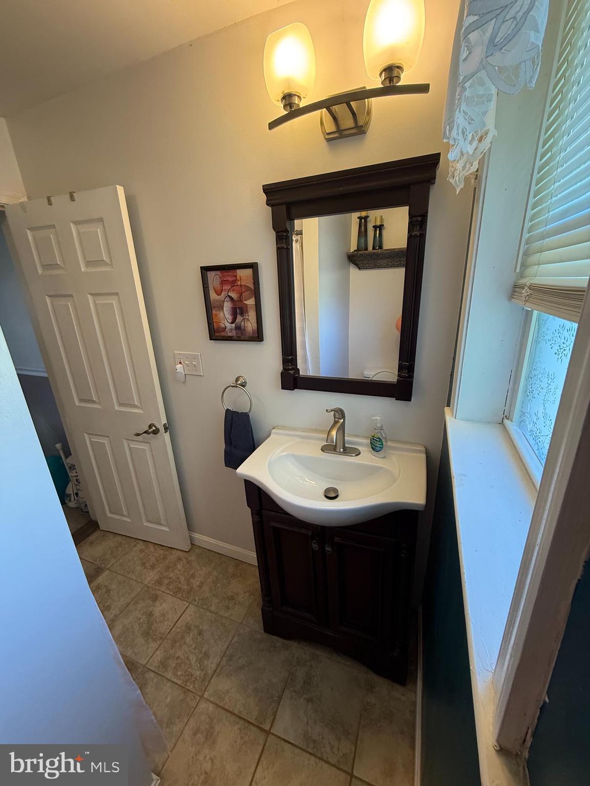 2235 Hawthorne Road Baltimore, MD 21220 - Photo 19 of 35 a bathroom with a sink and a mirror