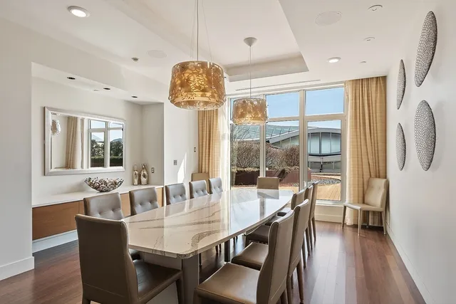 a dining room with furniture a chandelier and wooden floor