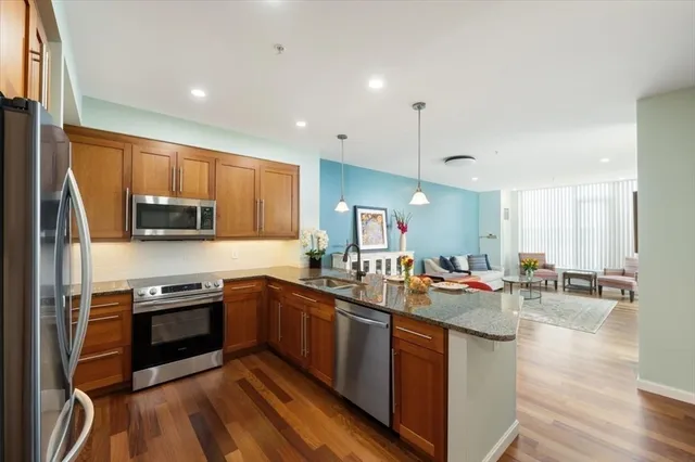 a kitchen with stainless steel appliances granite countertop a sink stove and refrigerator