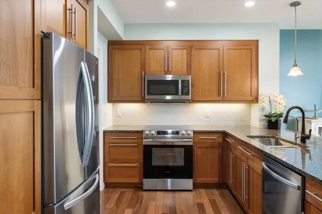 a kitchen with stainless steel appliances granite countertop a refrigerator stove and sink