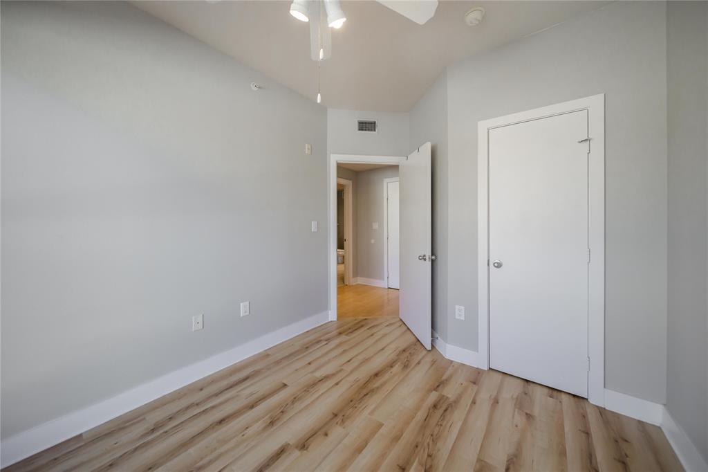 4414 Cedar Springs Road, Unit 214 Dallas, TX 75219 - Photo 15 of 29 Unfurnished bedroom with light wood-style flooring and ceiling fan