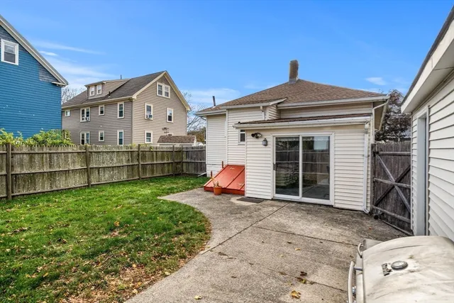a view of a house with a small yard and wooden fence