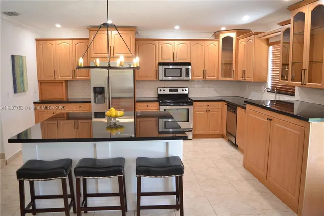 a kitchen with stainless steel appliances granite countertop a sink and a refrigerator
