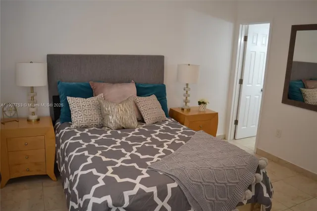 a bedroom with a large bed and a flat tv screen on dresser