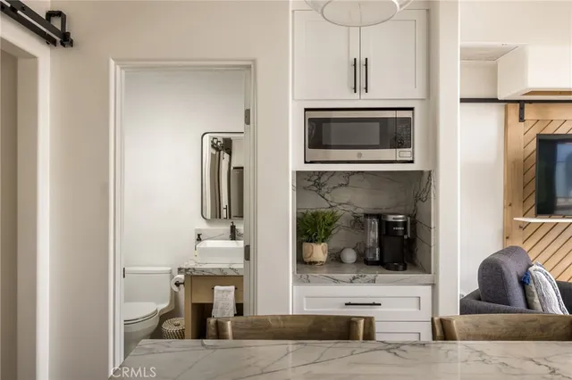 a kitchen with stainless steel appliances granite countertop a table chairs and a chandelier