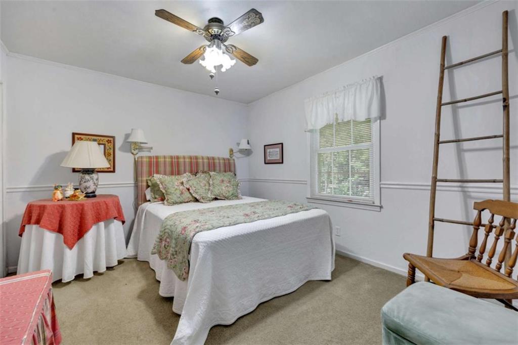 103 Gabriel Way Social Circle, GA 30025 - Photo 44 of 70 a spacious bedroom with a bed and a chandelier