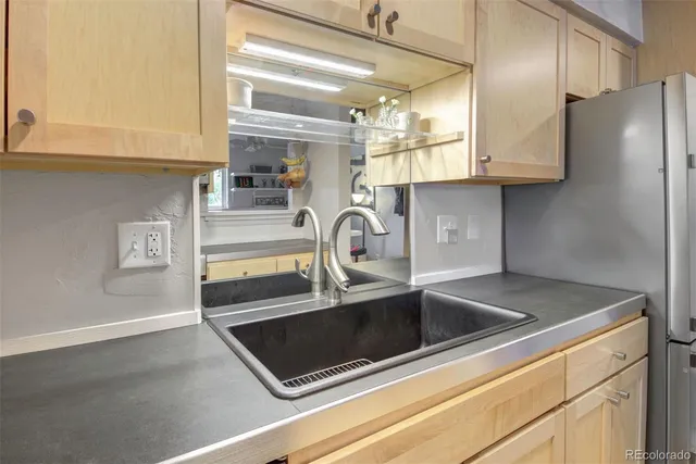 a kitchen with stainless steel appliances granite countertop a sink and a refrigerator
