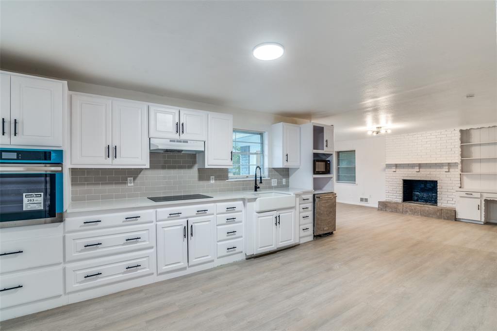 3308 Ranch Drive Garland, TX 75041 - Photo 13 of 25 a large kitchen with granite countertop a stove top oven a sink a dining table and chairs