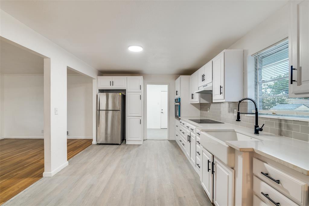 3308 Ranch Drive Garland, TX 75041 - Photo 14 of 25 a kitchen with granite countertop a sink a counter space and stainless steel appliances
