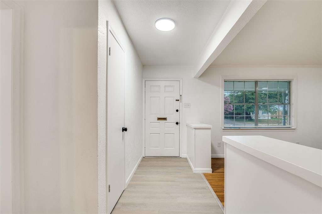 3308 Ranch Drive Garland, TX 75041 - Photo 3 of 25 a hallway with white doors wooden floor and front door