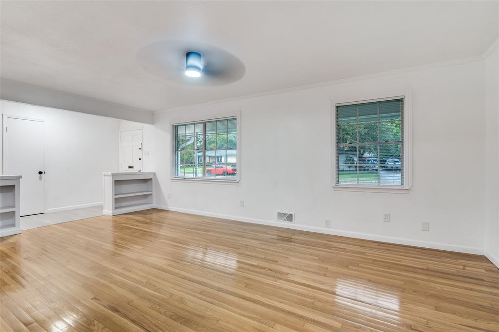 3308 Ranch Drive Garland, TX 75041 - Photo 5 of 25 an empty room with wooden floor and windows