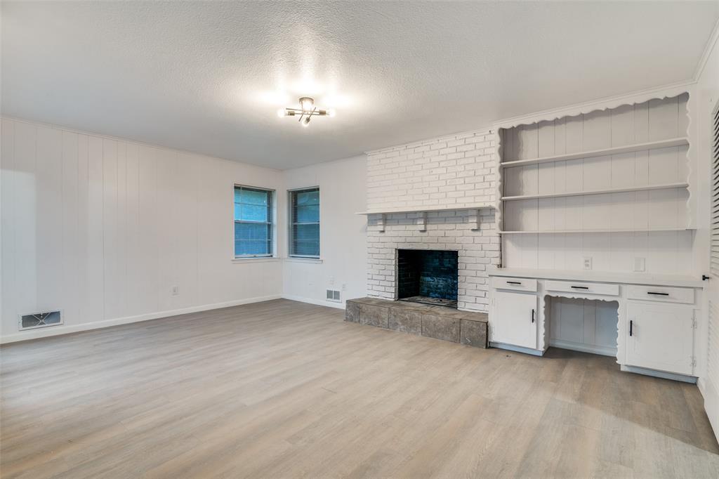 3308 Ranch Drive Garland, TX 75041 - Photo 6 of 25 an empty room with a fireplace and cabinet