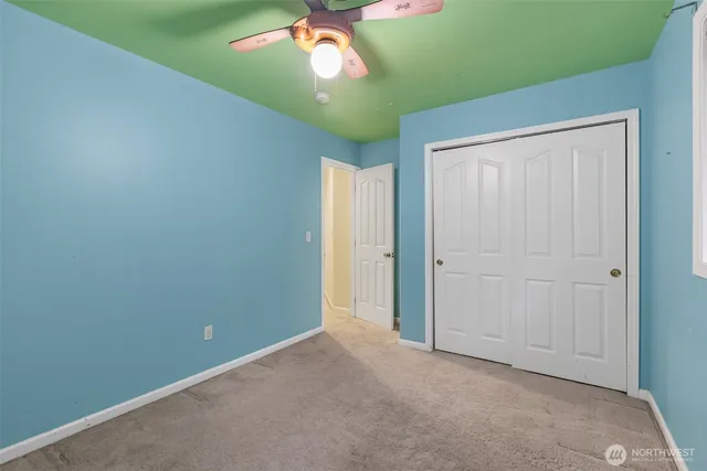 an empty room with a chandelier fan and a chandelier fan