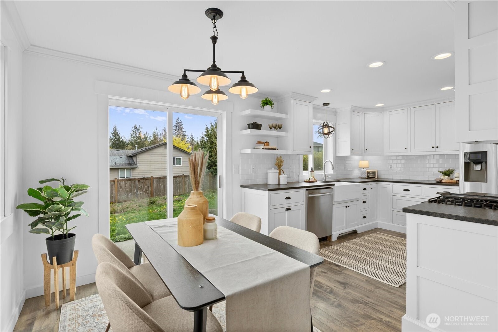208 Shantel Street Mount Vernon, WA 98274 - Photo 7 of 31 a kitchen with stainless steel appliances kitchen island granite countertop a refrigerator a stove a sink dishwasher and white cabinets with wooden floor