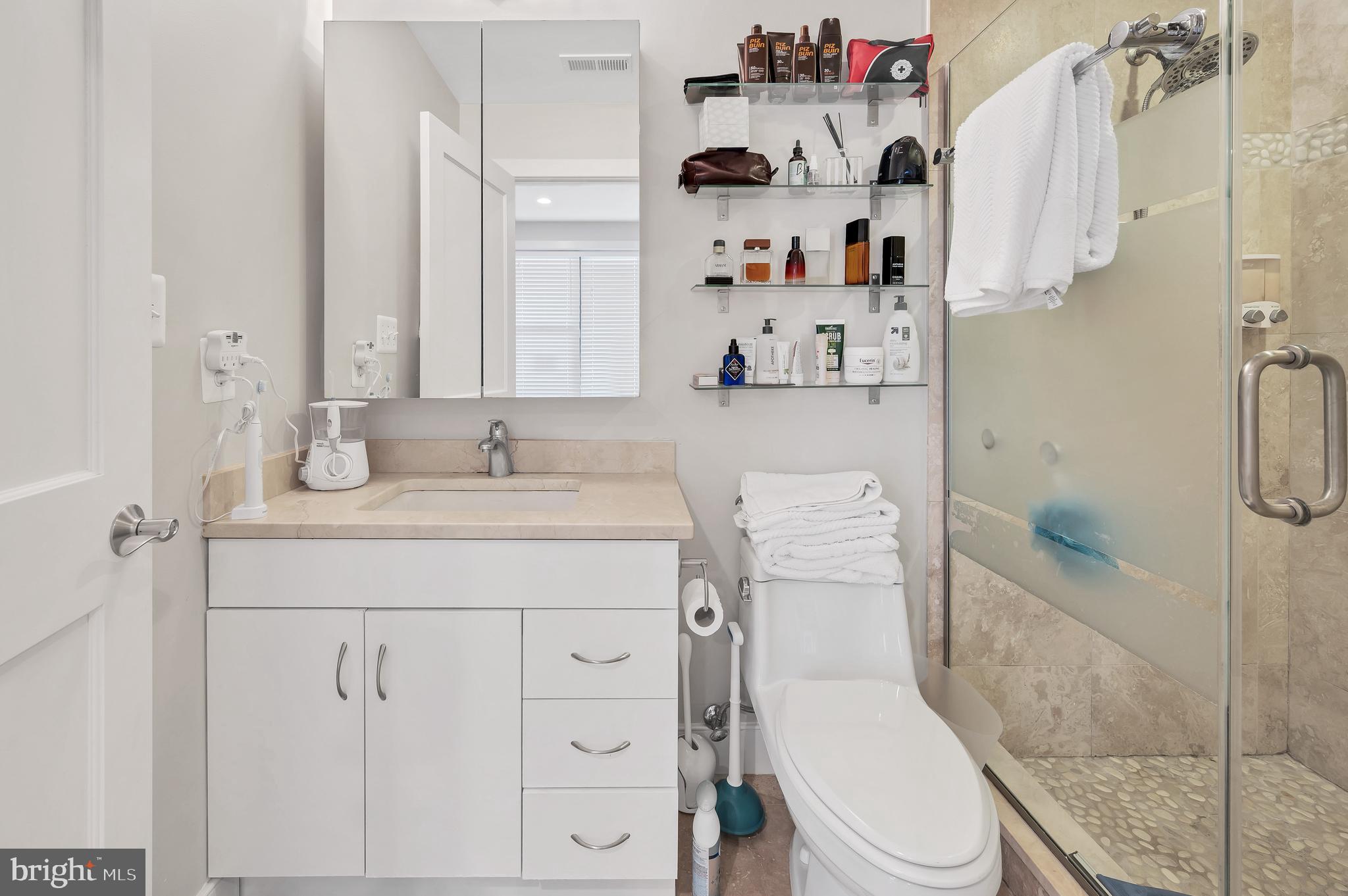2444 Ontario Road Northwest, Unit 2 Washington, DC 20009 - Photo 15 of 29 a bathroom with a granite countertop sink a toilet and a shower