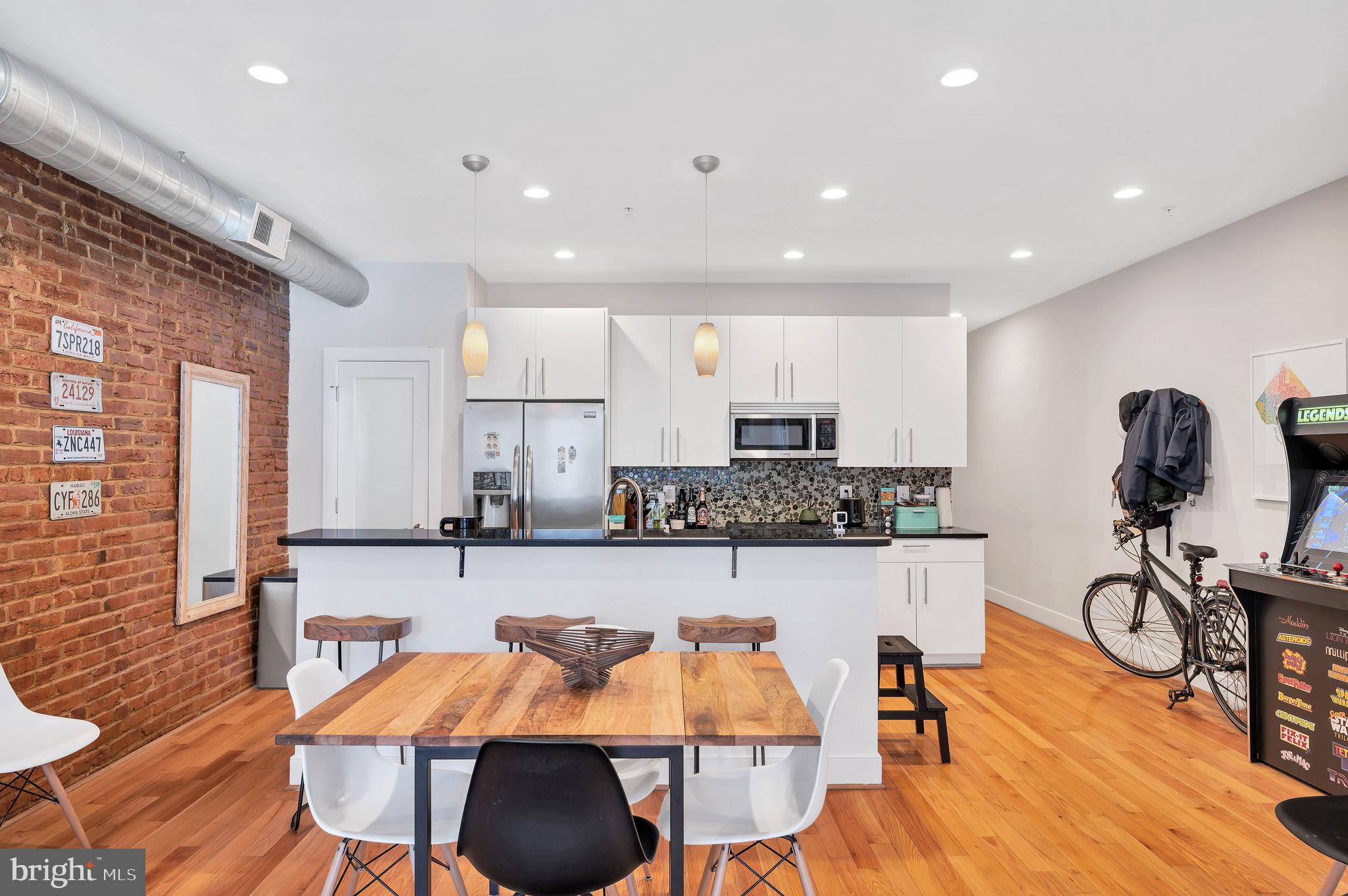 2444 Ontario Road Northwest, Unit 2 Washington, DC 20009 - Photo 6 of 29 a kitchen with stainless steel appliances granite countertop a table chairs stove and wooden floor