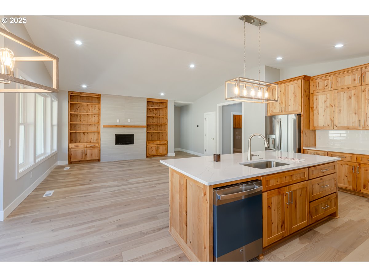 413 Meadows Drive Nehalem, OR 97131 - Photo 12 of 13 a kitchen with kitchen island a sink appliances and cabinets