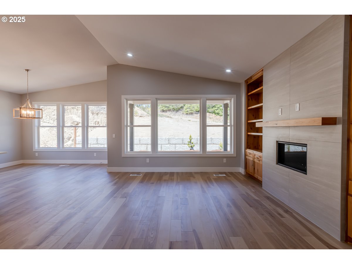 413 Meadows Drive Nehalem, OR 97131 - Photo 8 of 13 a view of an empty room with a fireplace and a window