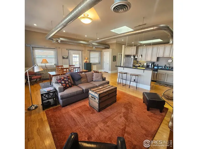 a living room with furniture fireplace and large windows