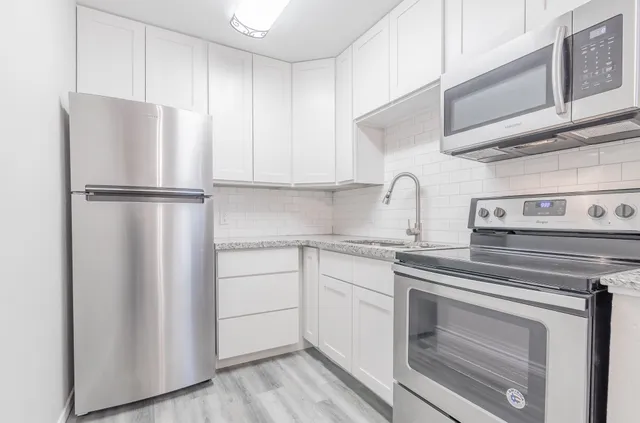 a kitchen with cabinets appliances and a counter space