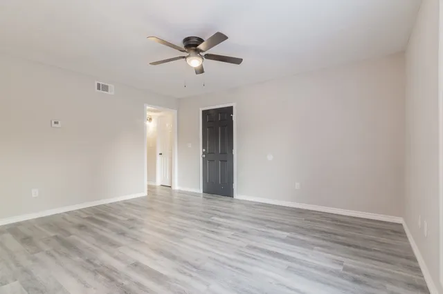 a view of an empty room with wooden floor