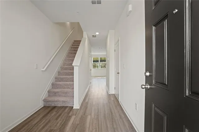 a view of a hallway with wooden floor and stairs