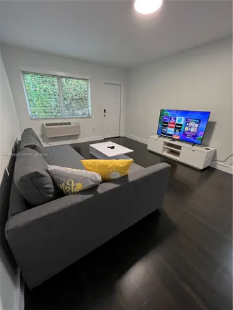 a living room with furniture and a pool table
