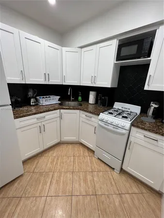 a kitchen with a sink a stove and cabinets
