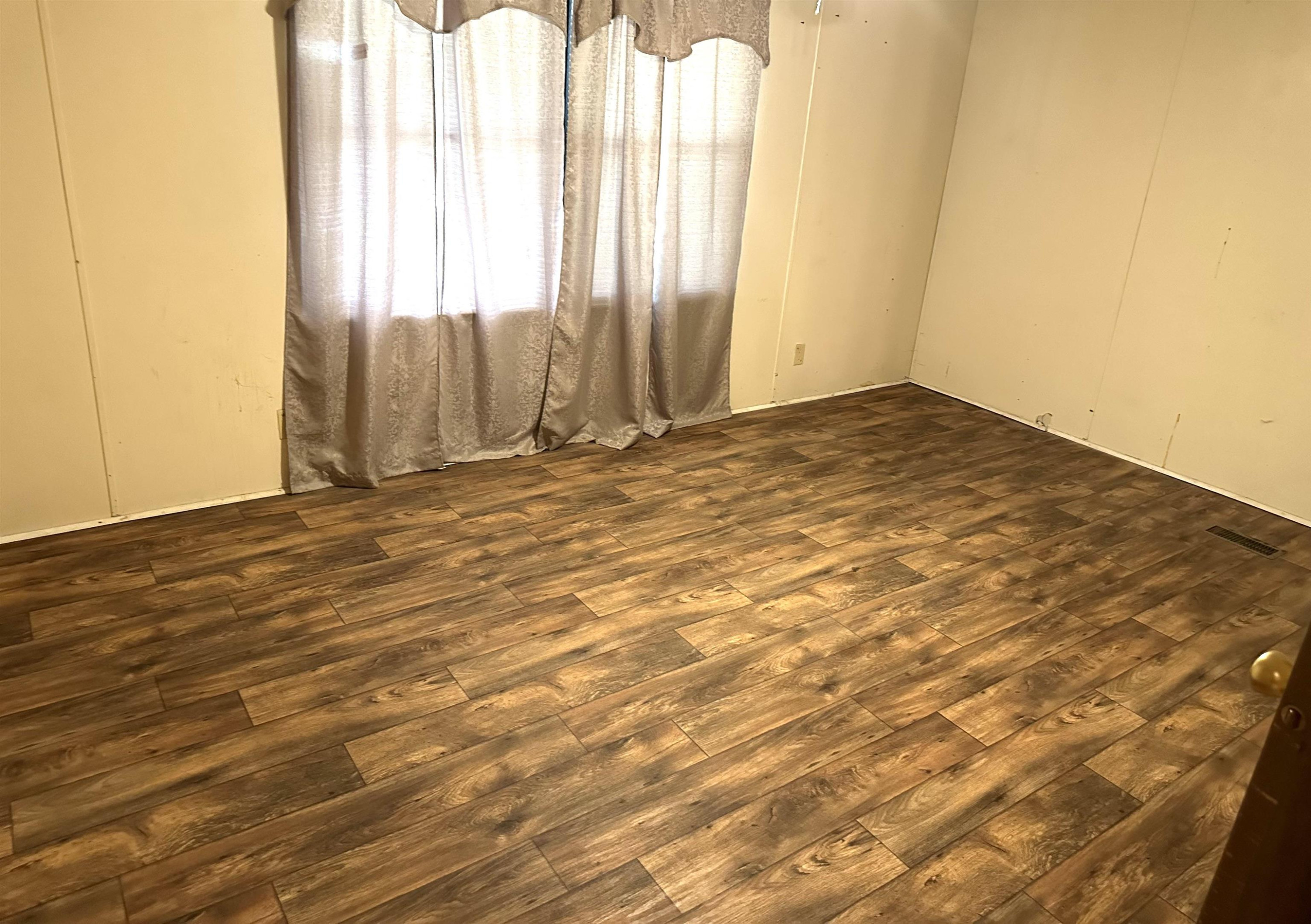 3702 Litt Wilson Road Finger, TN 38334 - Photo 7 of 14 an empty room with wooden floor and windows