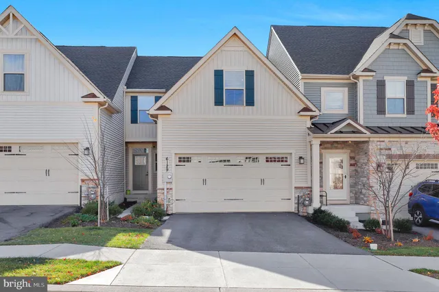 a view of a white house with large windows and yard
