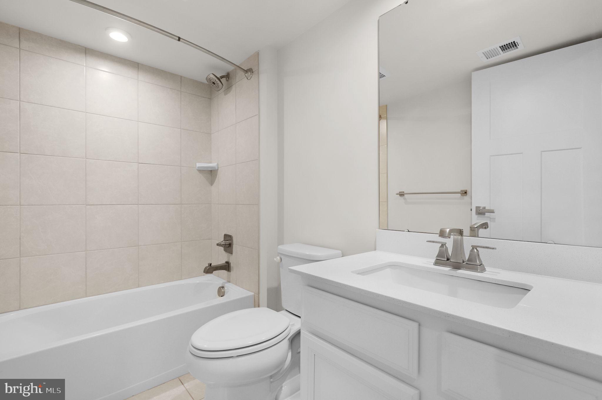 6129 Dock Street Frederick, MD 21703 - Photo 27 of 33 a bathroom with a granite countertop sink a toilet and shower