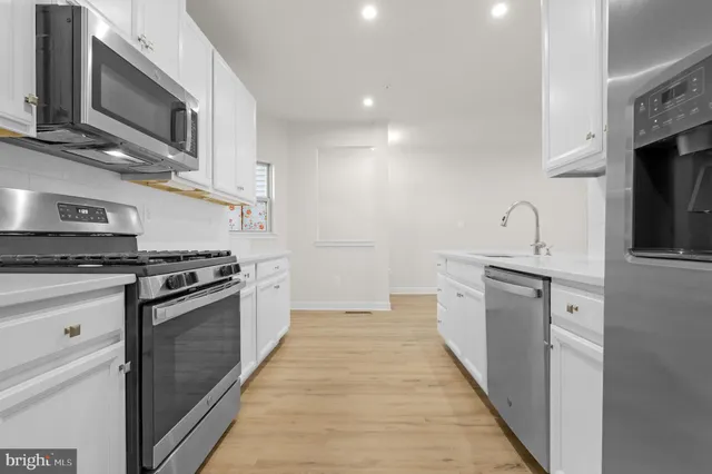 a kitchen with stainless steel appliances granite countertop a stove and a microwave