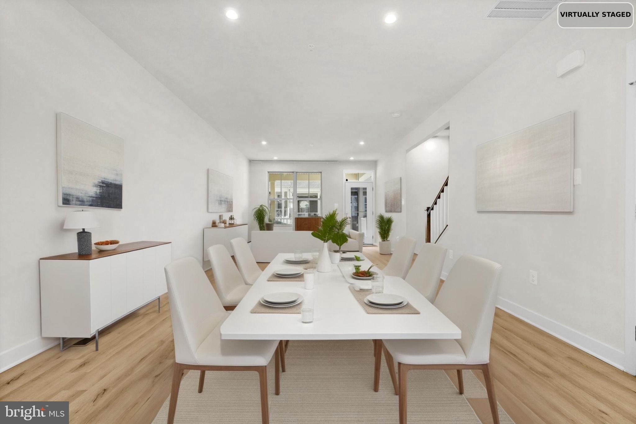 6129 Dock Street Frederick, MD 21703 - Photo 8 of 33 a view of a dining room and livingroom with furniture wooden floor a rug a potted plant and a chandelier