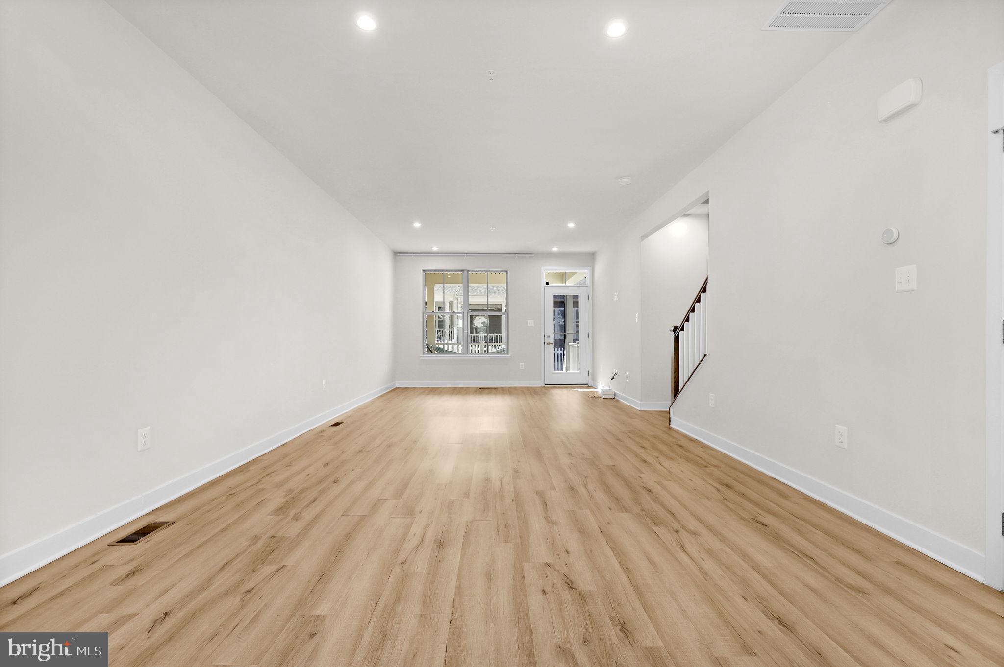 6129 Dock Street Frederick, MD 21703 - Photo 9 of 33 a view of an empty room with wooden floor and a window