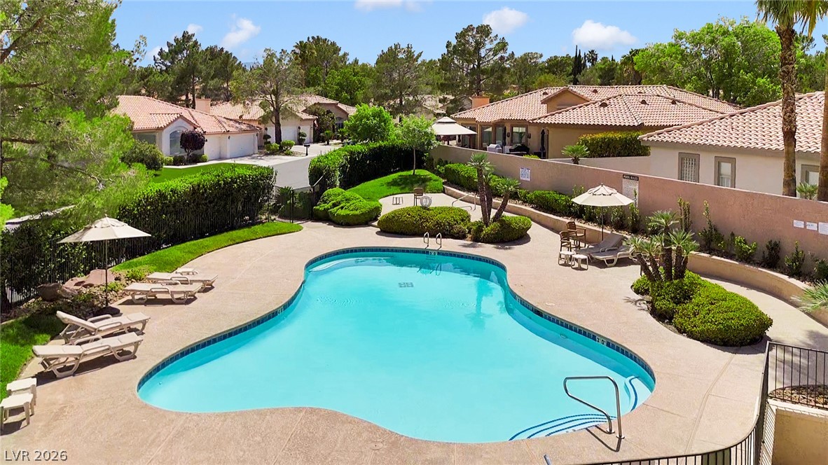 8981 Rivers Edge Drive Las Vegas, NV 89117 - Photo 59 of 69 An inviting community pool surrounded by lush landscaping and residential homes, ideal for leisurely afternoons.