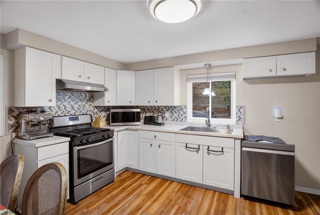 6361 Leechburg Road Verona, PA 15147 - Photo 8 of 26 a kitchen with granite countertop a stove sink and cabinets