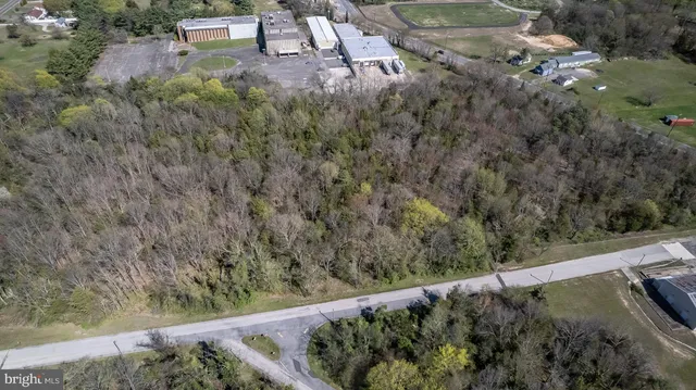 an aerial view of residential houses with outdoor space and trees