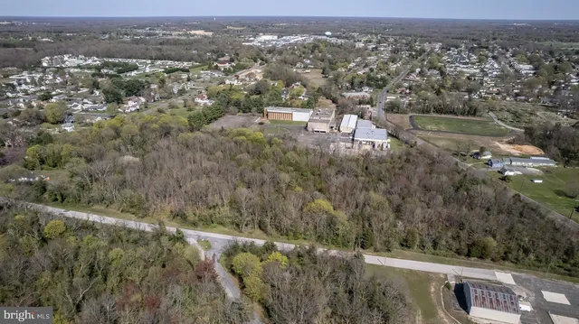 an aerial view of residential houses with outdoor space and trees